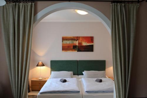 a bedroom with a bed with a green headboard at Ferienwohnungen Gästehaus Sonnenkreis in Ruhpolding