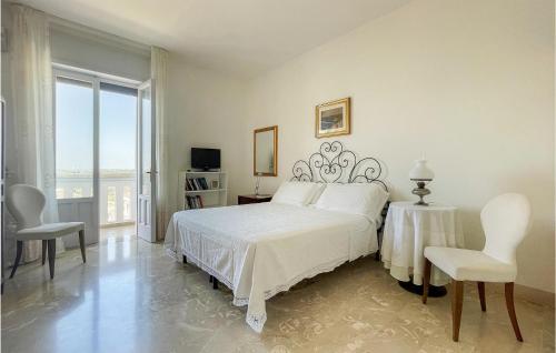 een witte slaapkamer met een bed en 2 stoelen bij 1 Bedroom Amazing Apartment In Castro in Minervino di Lecce