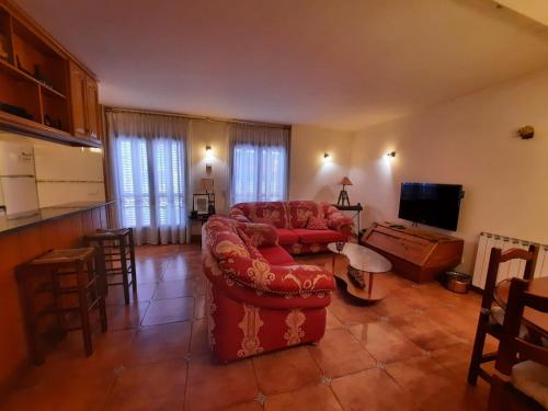 a living room with a red couch and a kitchen at ESPECTACULAR CASA RURAL CA L'ESQUERRÉ in Cerviá