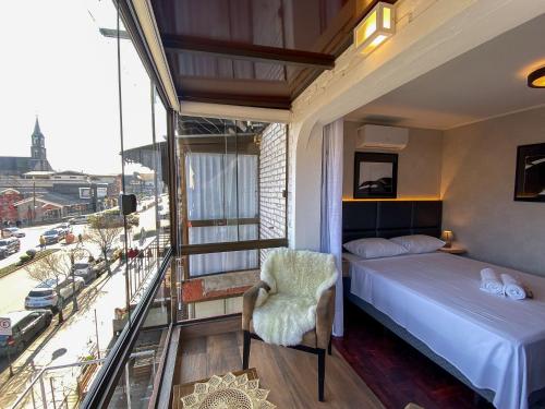 um quarto com uma cama e uma varanda em LOCAR-IN GRAMADO- 100m Rua Coberta em Gramado