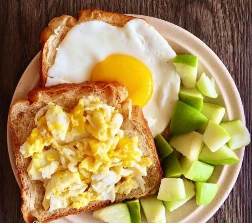 a plate of food with an egg on top of toast at Moon Light Guest House in Tissamaharama