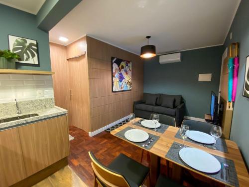 - une cuisine avec une table, des chaises et un canapé dans l'établissement LOCAR-IN GRAMADO- 100m Rua Coberta, à Gramado