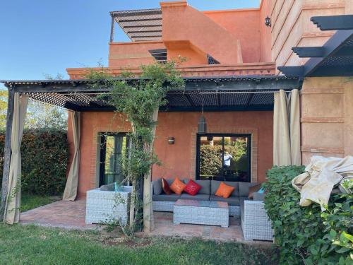 een patio met een bank voor een huis bij atlas golf resort marrakech " Maison à 03 chambres avec jardin privé " in Marrakesh