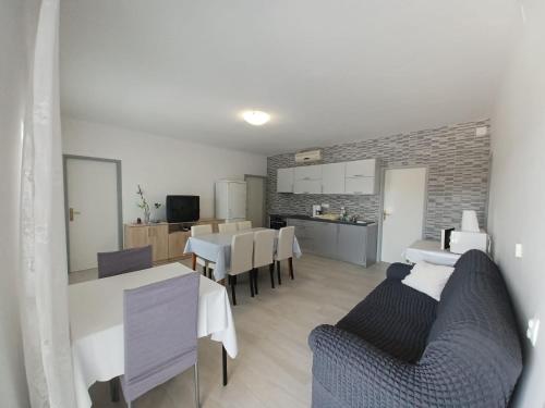 a kitchen and dining room with white tables and chairs at Apartments with a parking space Seline, Paklenica - 6628 in Starigrad