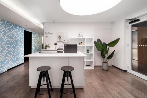 a kitchen with two stools and a counter with a laptop at Stey Beijing Sanlitun Boutique Hotel in Beijing