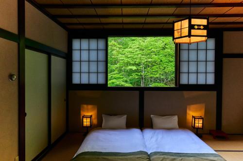 a bedroom with a large bed and a window at SOBAHOUSE Azumino in Azumino