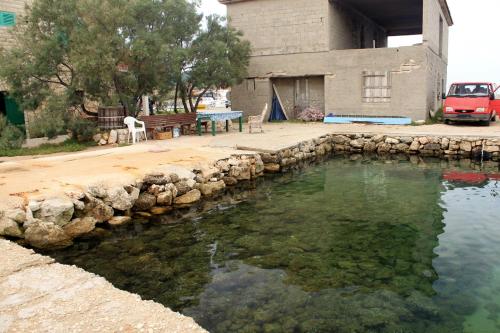 a pool of water in front of a building at Apartments and rooms by the sea Nevidjane, Pasman - 11902 in Neviđane