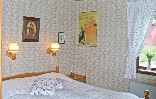 ムンケドルにあるLovely Home In Munkedal With House A Mountain Viewのベッドルーム1室(ベッド1台付)、壁にポスターが備わります。
