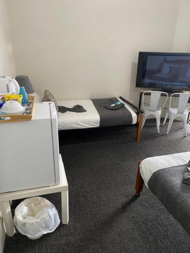 a room with two beds and a flat screen tv at Cornwall Hotel in Moonta