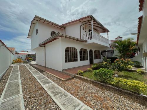 a white house with a pathway in front of it at Anapoima -Liberia in Anapoima