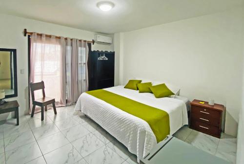 a bedroom with a large bed and a chair at Carpao Lodging Galapagos in Puerto Ayora
