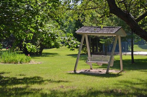 a park bench with a gazebo in the grass at Country House Resort in Sister Bay