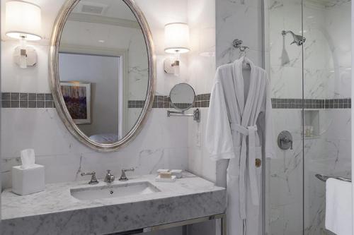 uma casa de banho branca com um lavatório e um espelho em The Lenox em Boston