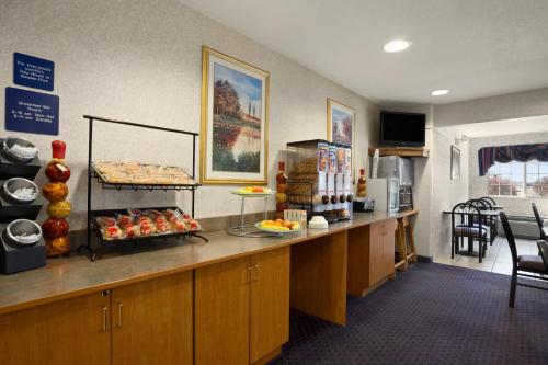 a cafeteria with a counter with food on it at Ramada by Wyndham Bloomington I-55 and I-74 IL in Bloomington