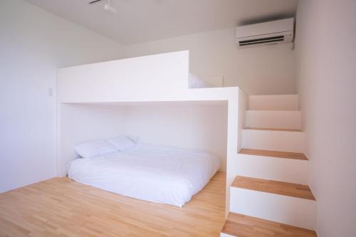 a small bedroom with a bed and a staircase at Trailer room - Vacation STAY 06457v in Makinohara