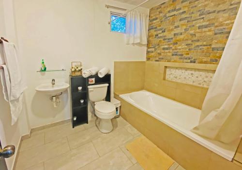 a bathroom with a tub and a toilet and a sink at Carpao Lodging Galapagos in Puerto Ayora