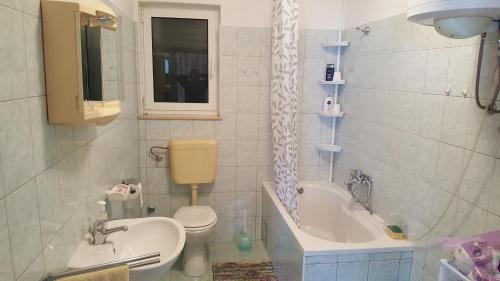 a bathroom with a sink and a toilet and a tub at Apartments by the sea Slatine, Ciovo - 4844 in Slatine