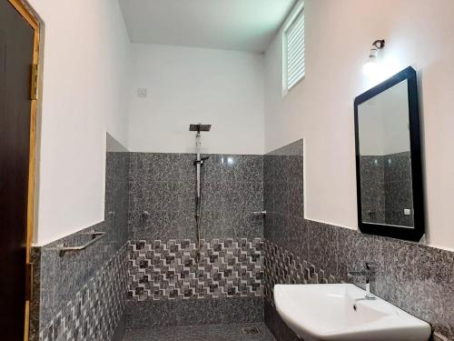 Hotel krish في كالكوداه: حمام مع حوض ومرآة