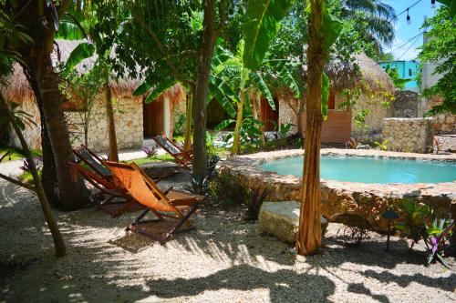 a resort with a pool and chairs and trees at Aldea Che-Eek , con acceso a un club de playa privado in Bacalar