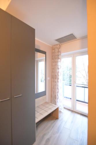 a living room with a large window and a cabinet at ALMA B&B Home Cosenza in Cosenza