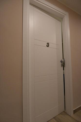 a white closet door with a metal handle at ALMA B&B Home Cosenza in Cosenza
