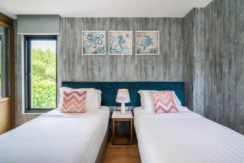 um quarto com 2 camas e uma mesa com um candeeiro em Mövenpick Pool Villa4BR-PrivatePool(SHA CERTIFIED) em Na Jomtien