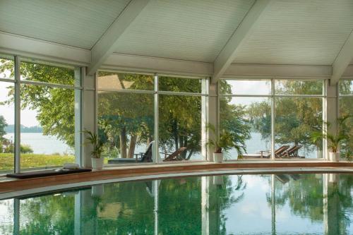an indoor swimming pool in a house with windows at Hotel Dieksee - Collection by Ligula in Malente