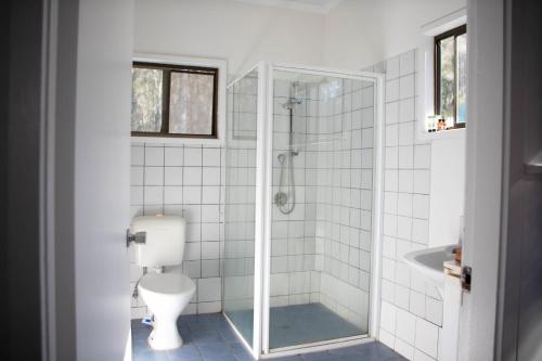 a bathroom with a shower and a toilet and a sink at Arts Factory by Nomads in Byron Bay