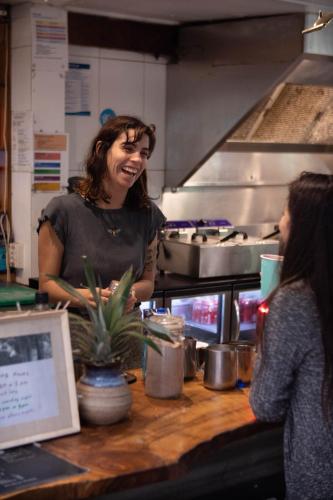 a woman standing behind a counter in a kitchen at Arts Factory by Nomads in Byron Bay