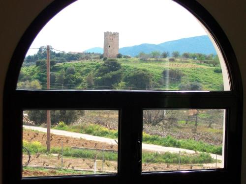 an arched window with a view of a field at Villa Vravrona Tower & Suites in Markopoulo