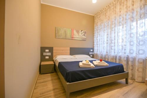 a bedroom with a bed with towels on it at ALMA B&B Home Cosenza in Cosenza