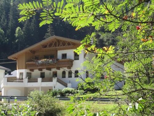 a white building with a wooden roof at Alpenapart Walch in Jerzens