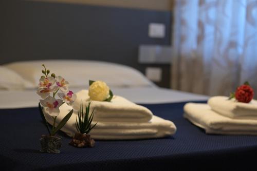 a table with towels and flowers on top of it at ALMA B&B Home Cosenza in Cosenza