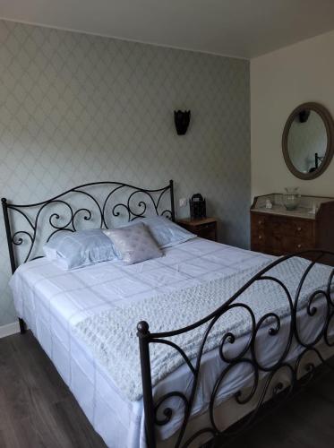 une chambre avec un lit avec des draps blancs et un miroir dans l'établissement Appartement Au Cigogneau Wifi-Netflix-Balcon-Parking, à Munster