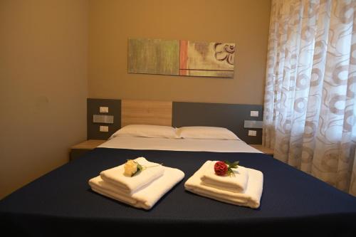 a bedroom with a bed with towels on it at ALMA B&B Home Cosenza in Cosenza