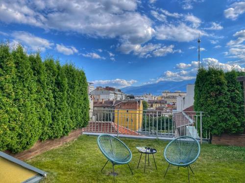 een patio met 2 stoelen en een tafel op het gras bij ATRIUM Boutique Hotel Sofia in Sofia