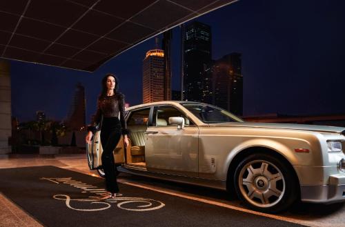 een vrouw staat voor een auto bij Fairmont Dubai in Dubai