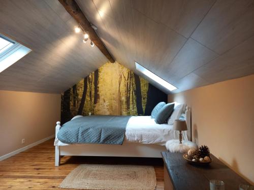 a bedroom with a bed with a painting on the wall at Le Clos du Cerf - La Renardière in Stoumont