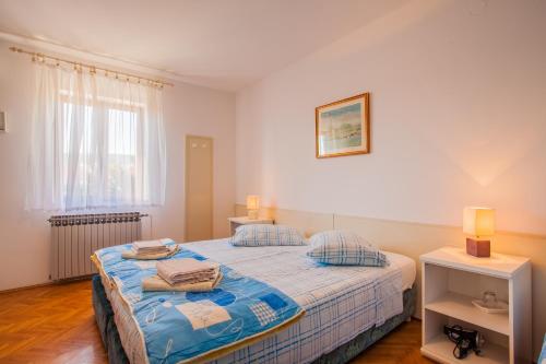 a bedroom with a bed and two tables and a window at Rooms with a parking space Cres - 2512 in Cres