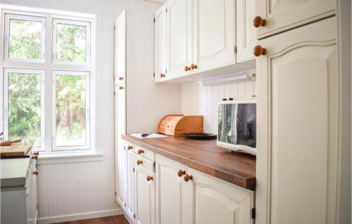 una cucina con armadi bianchi e bancone con forno a microonde di Stunning Home In Brekke With Kitchen a Brekke