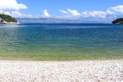 a large body of water with a rocky beach at Double Room Jelsa 4041d in Jelsa
