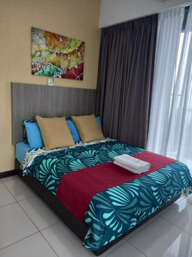um quarto com uma cama com um cobertor vermelho e azul em Sunset View 969 PD Waterfront em Porto Dickson