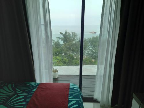 a bedroom with a window with a view of the ocean at Sunset View 969 PD Waterfront in Port Dickson