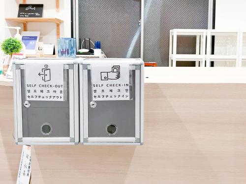 two electrical boxes sitting on top of a wooden floor at Osaka Nipponbashi EVISU HOSTEL エビスホステル in Osaka