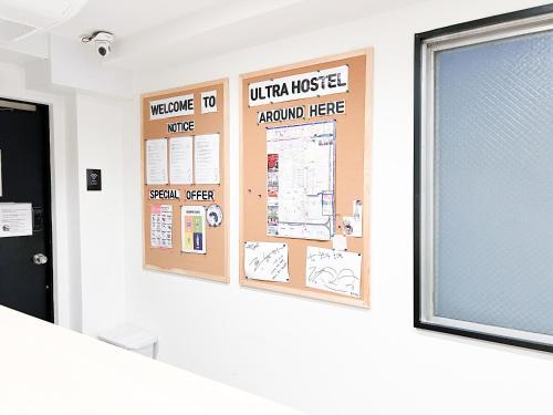 a wall with a bulletin board in a room at Osaka Nipponbashi EVISU HOSTEL エビスホステル in Osaka