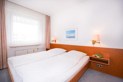ein Schlafzimmer mit einem großen weißen Bett und einem Fenster in der Unterkunft Hanseat I Whg 72 in Grömitz