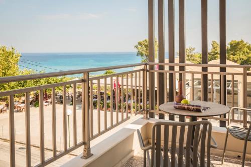 a balcony with a table and chairs and the ocean at Skala Hotel in Skala Kefalonias
