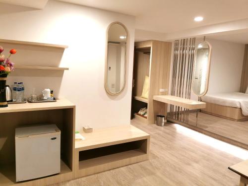 Habitación con 1 dormitorio con cama y espejos en Sakol Hotel en Hat Yai