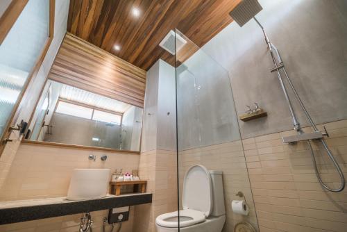 a bathroom with a toilet, shower, and sink at Banana Fan Sea Resort - SHA Extra Plus Certified in Chaweng