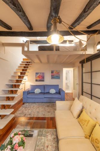 a living room with a blue couch and stairs at Itsasaurre - baskeyrentals in Ondárroa
